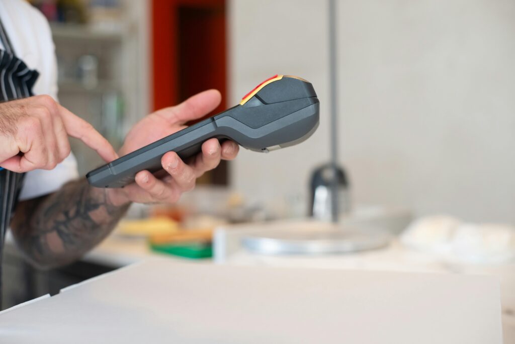 Restaurant staff using a modern wireless POS terminal for transactions.