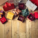 Elegant jewelry gifts with shopping bags on wooden floor, perfect for holiday celebrations.