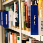 Close-up of a library shelf with books on internet and technology. Ideal for education-themed projects.