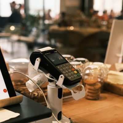 A digital payment terminal on a cozy café counter, suggesting a modern lifestyle.