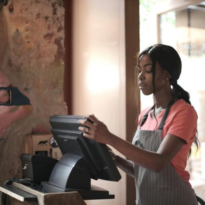 A diligent cashier processes sales in a charming store environment, enhancing customer service.